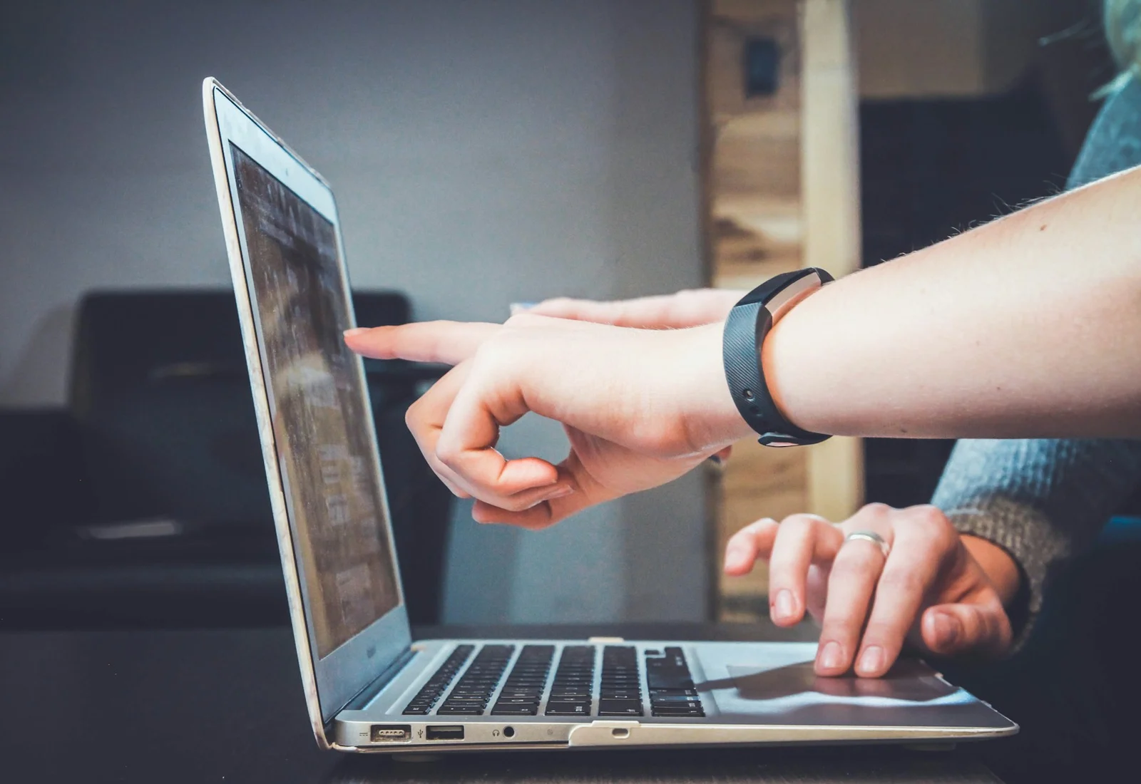 A hand working on a laptop during an online lesson